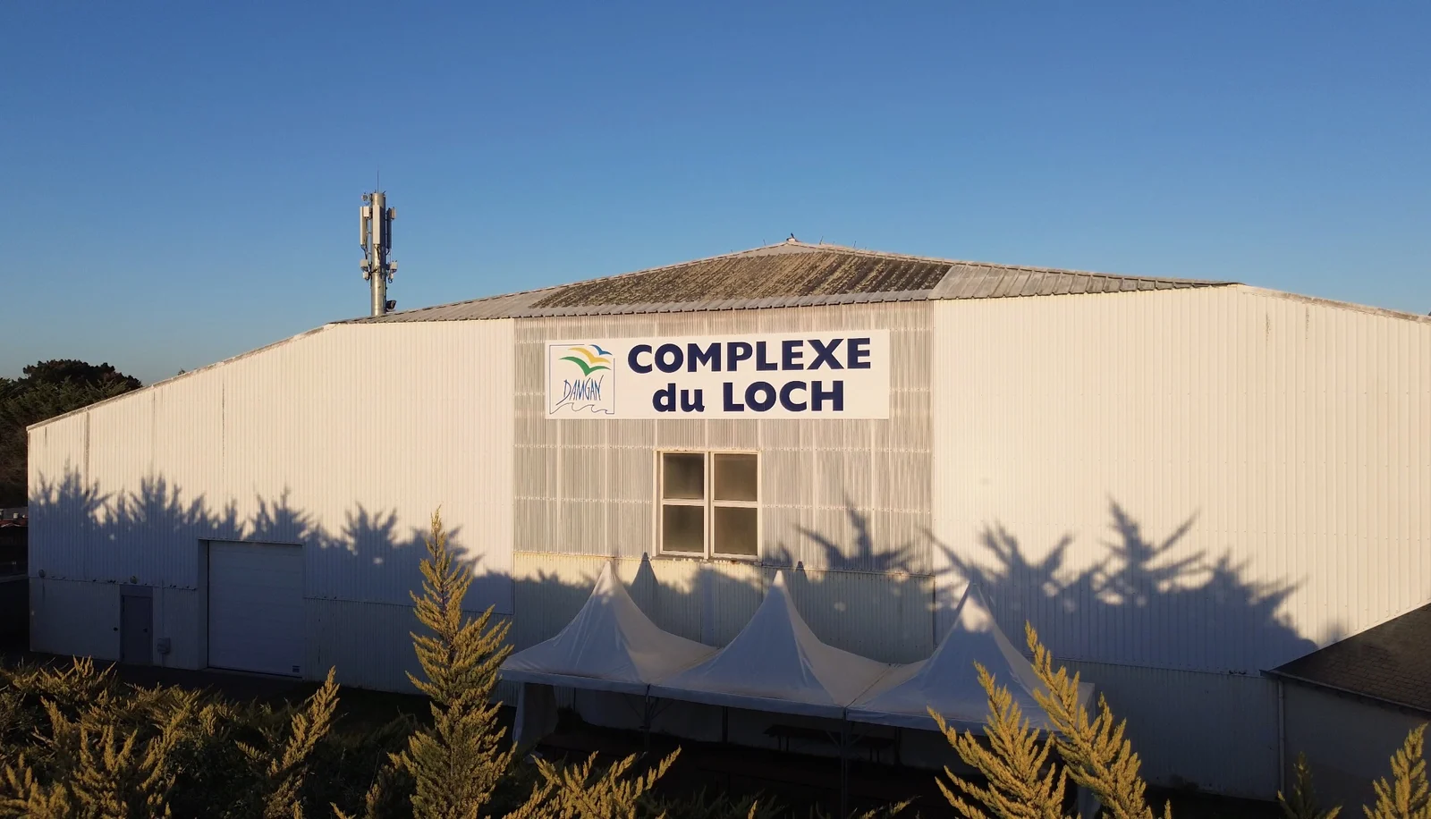 Le Complexe du Loch à Damgan au soleil couchant, avec ses barnums blancs devant la façade