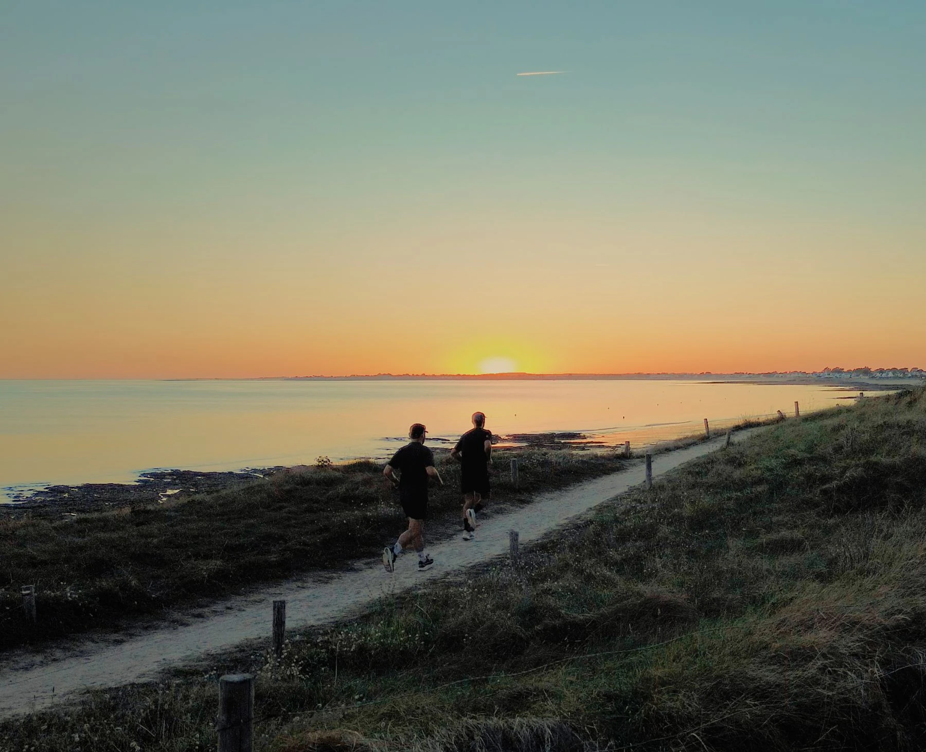 Deux coureurs sur le sentier côtier de Damgan au coucher du soleil